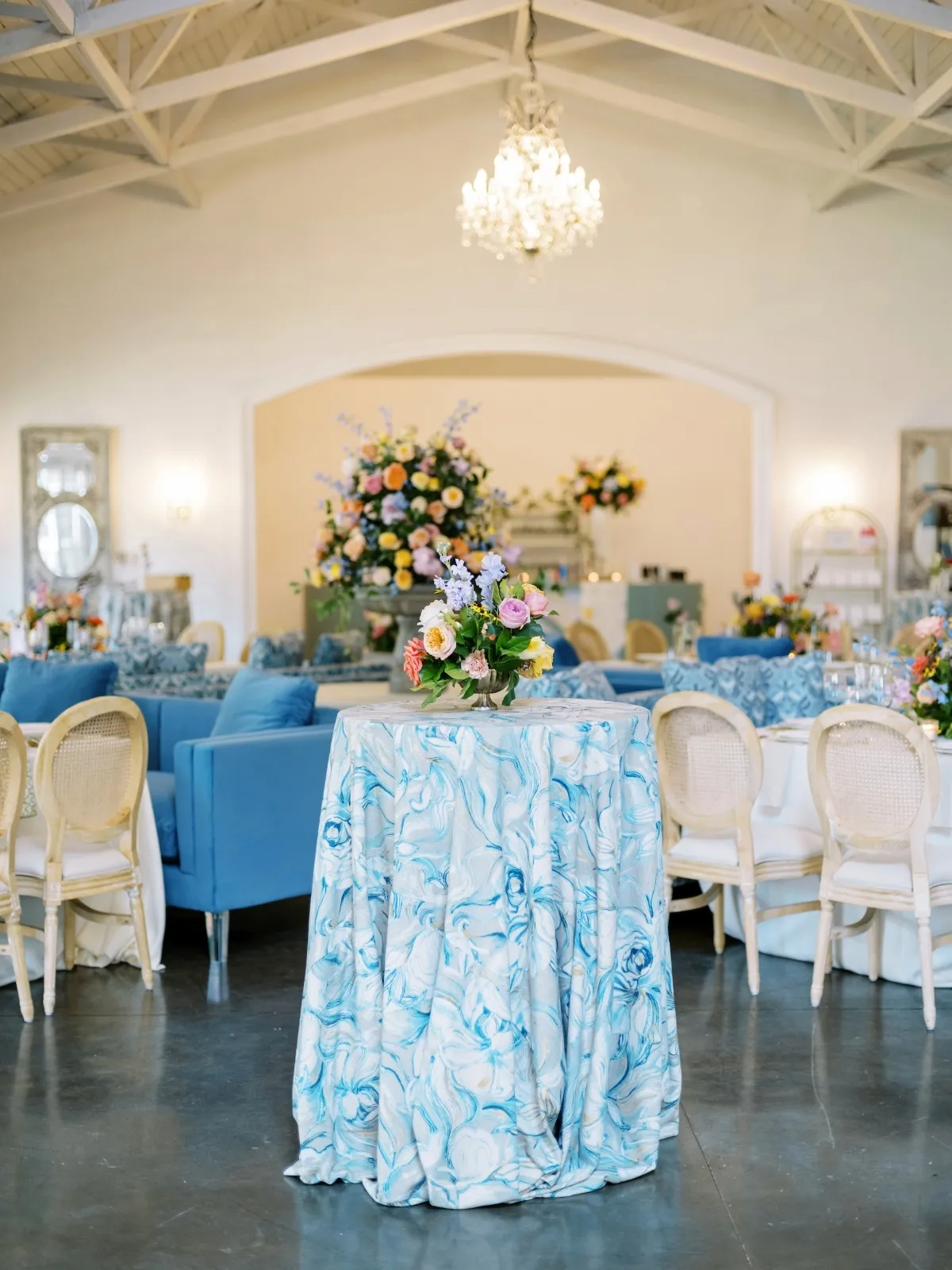 Cocktail table draped in blue marbled luxury linen within an elegant lounge setting.