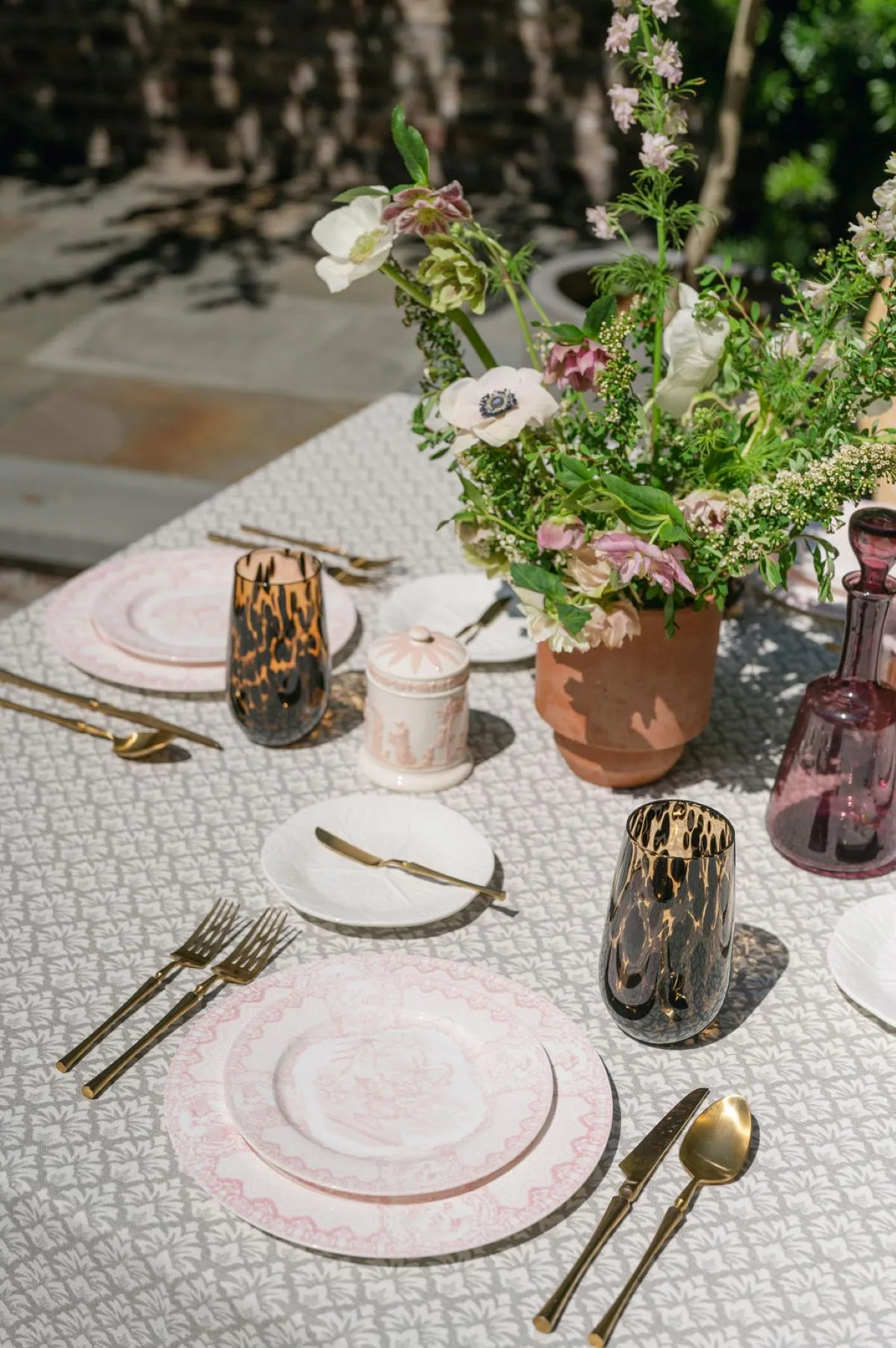 Neutral patterned luxury linen accented with pink china, gold flatware, and fresh garden florals.