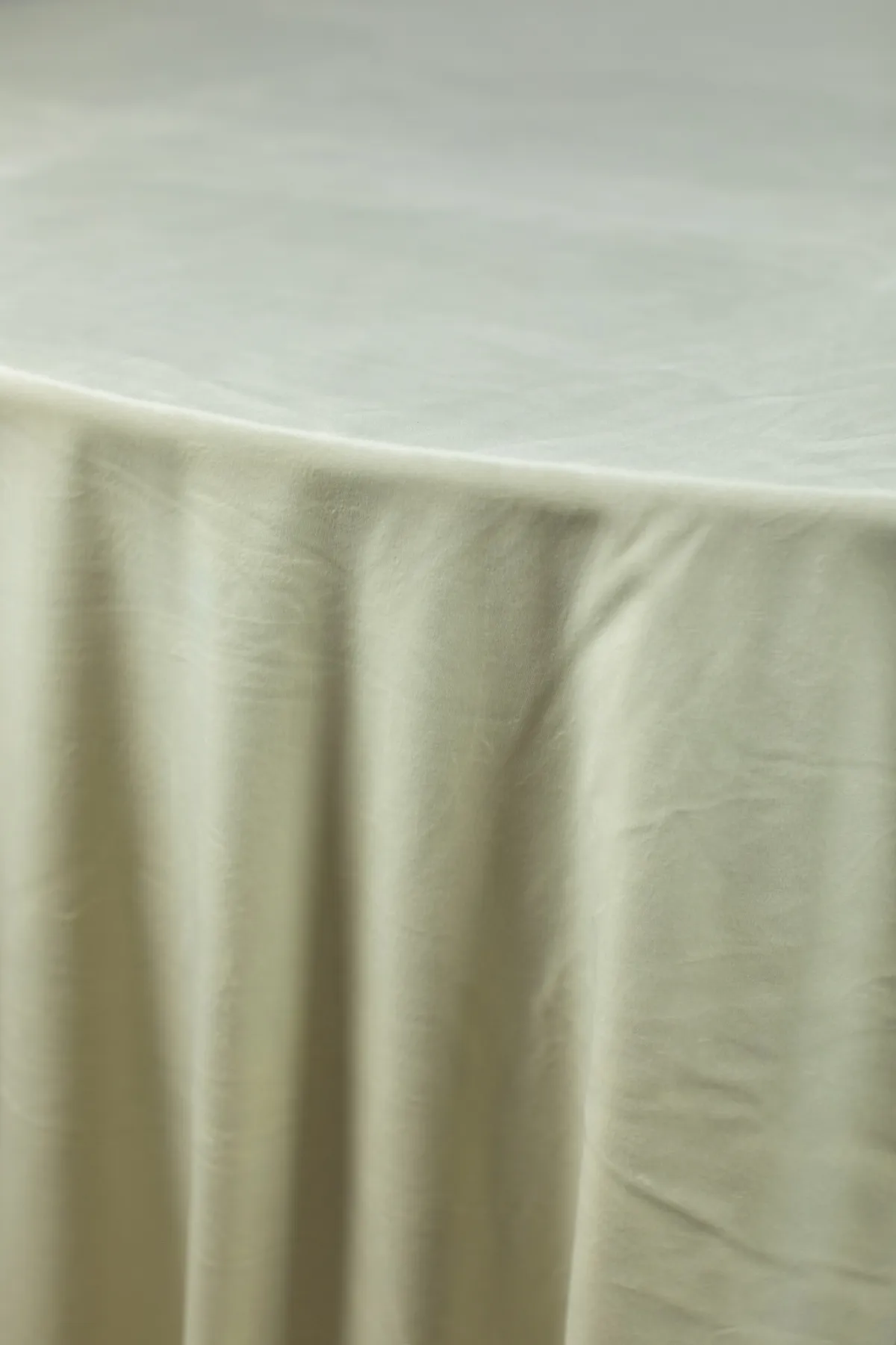 Soft sage velvet table linen showcasing smooth drape and subtle sheen.
