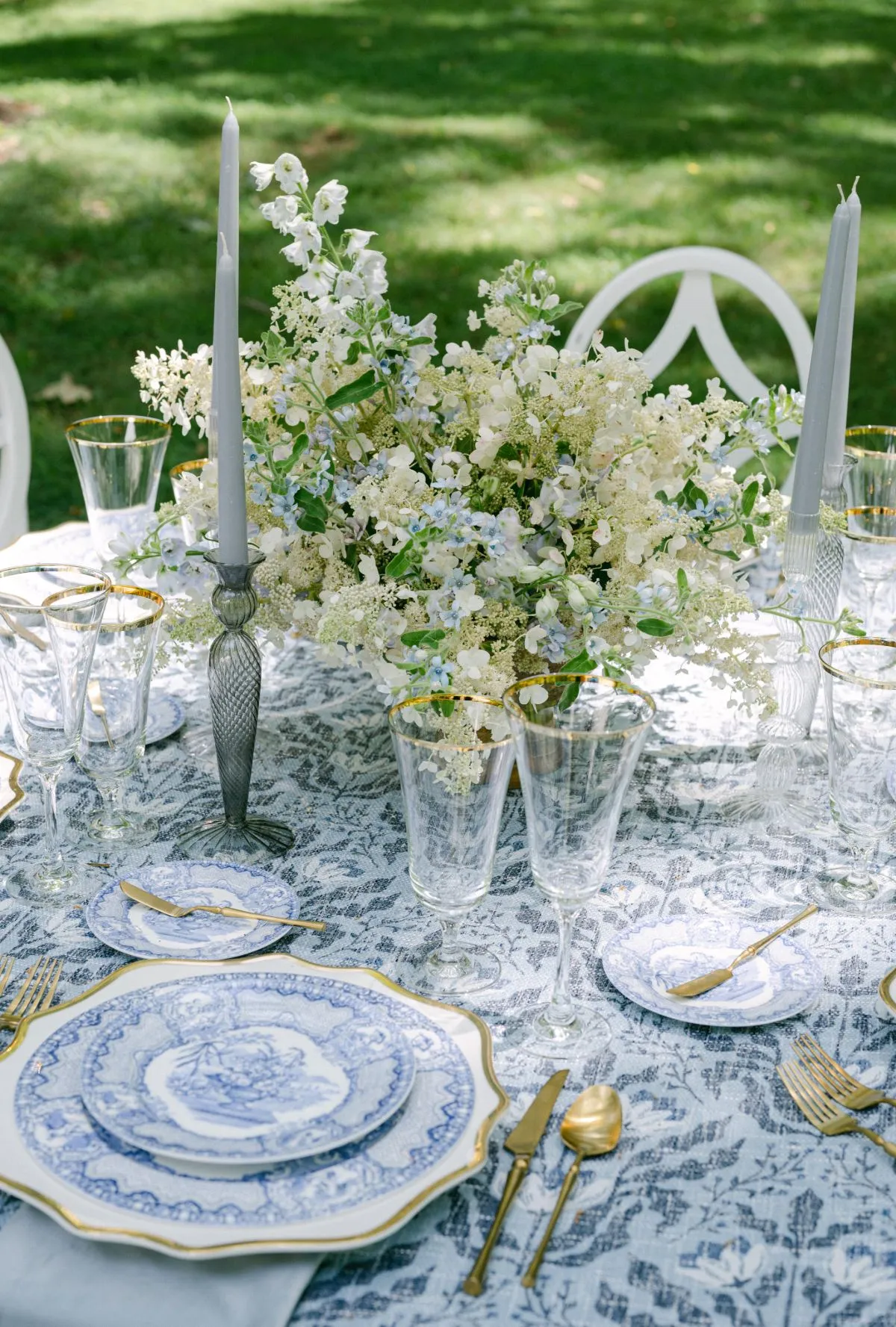 Custom blue-and-white wedding table linen with layered china and elegant glassware.
