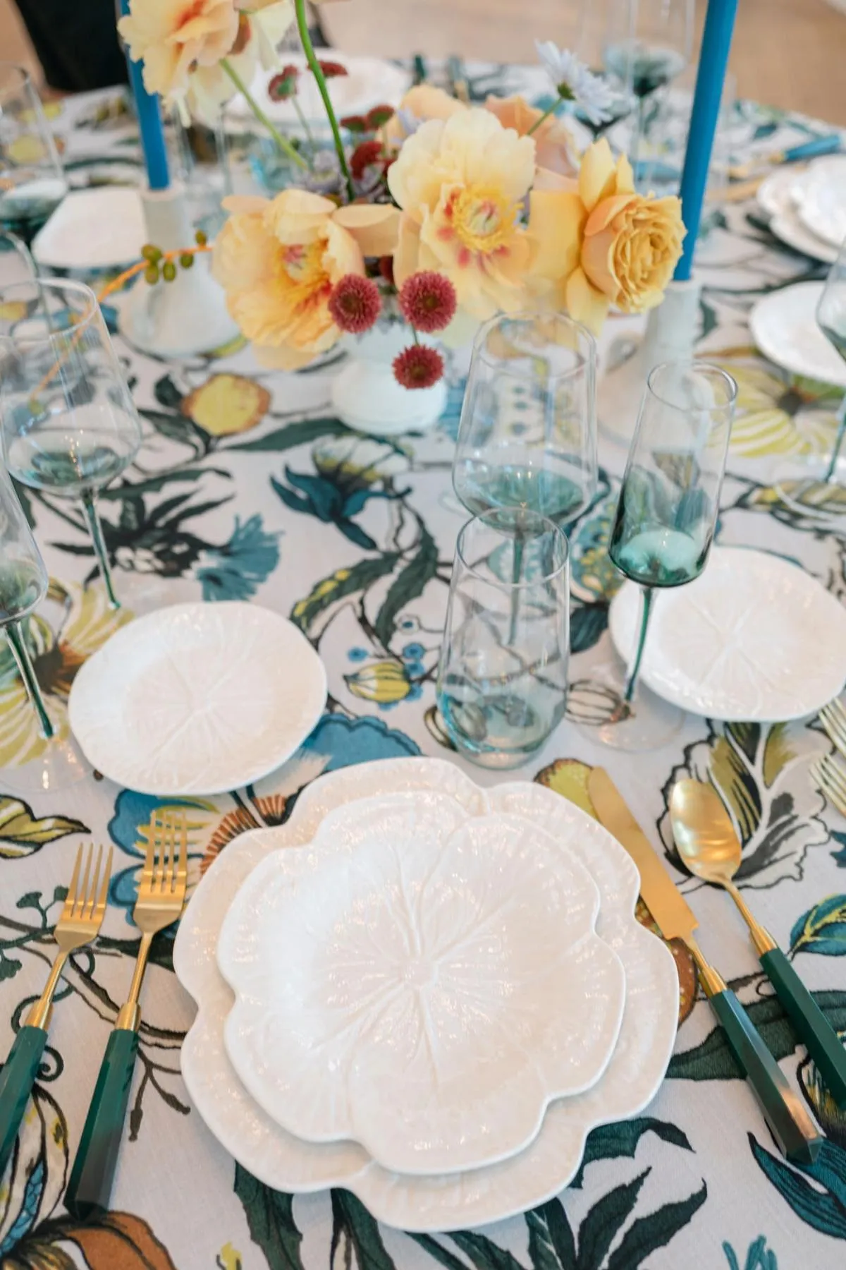 Close-up of luxury wedding table setting with floral centerpiece and botanical linen print.