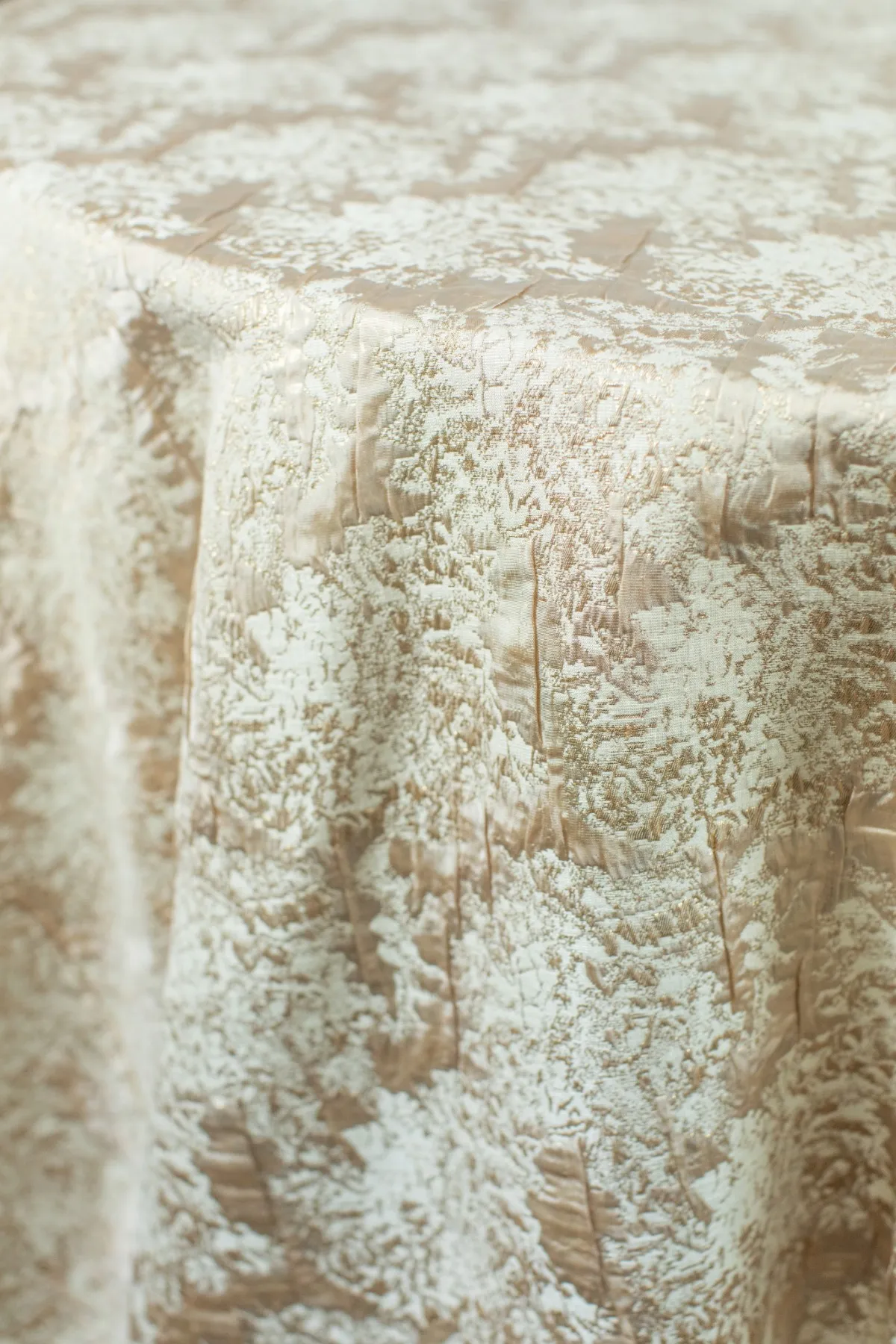 Close-up of textured luxury linen tablecloth showcasing intricate woven pattern and drape.