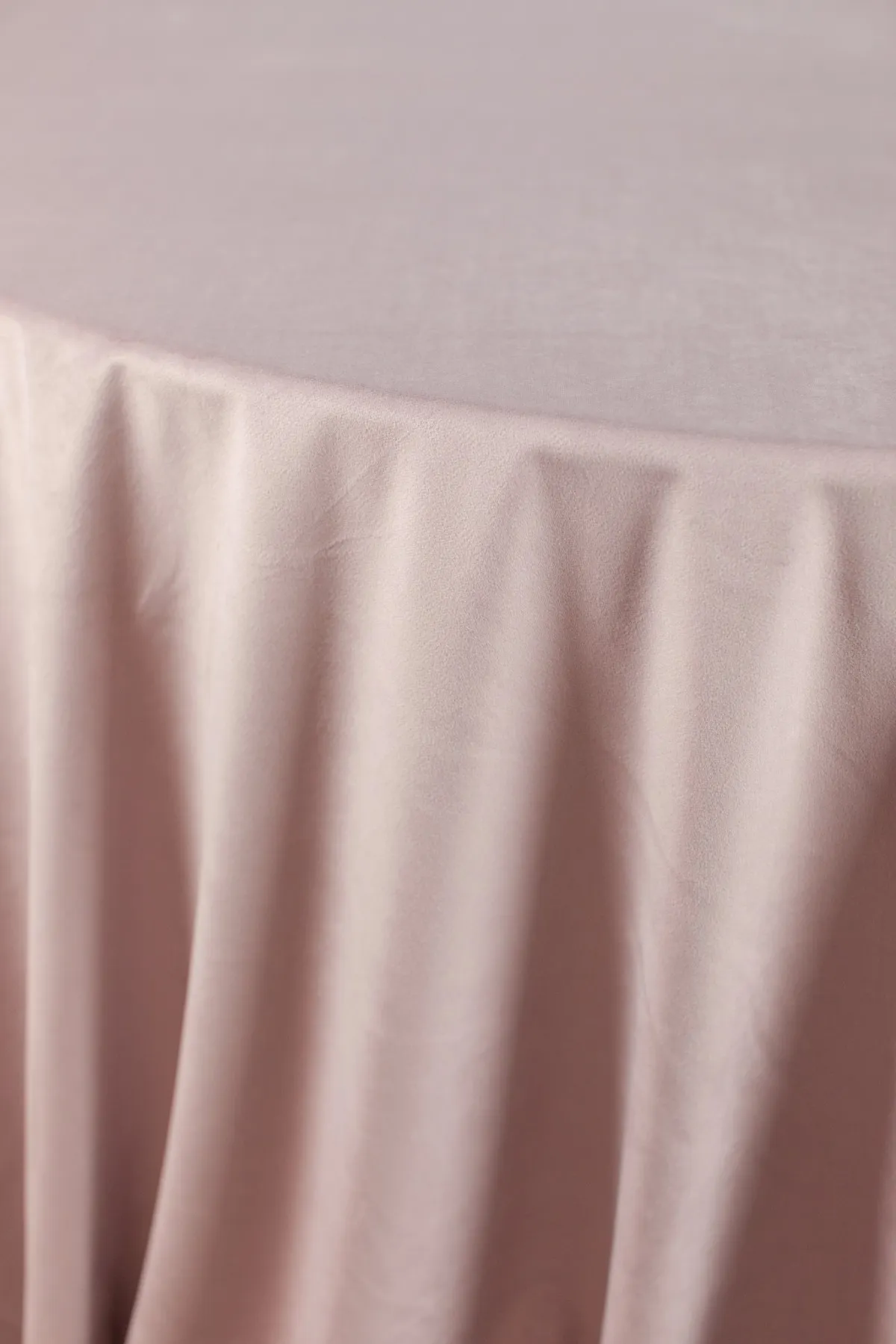 Blush pink tablecloth with soft gathered folds.