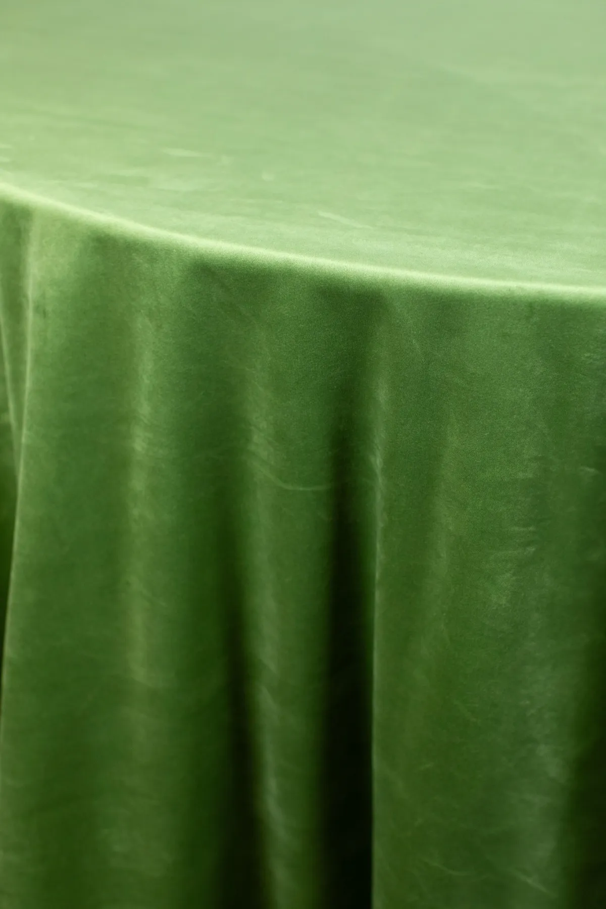 Emerald velvet table linen featuring rich color and fluid, elegant folds.