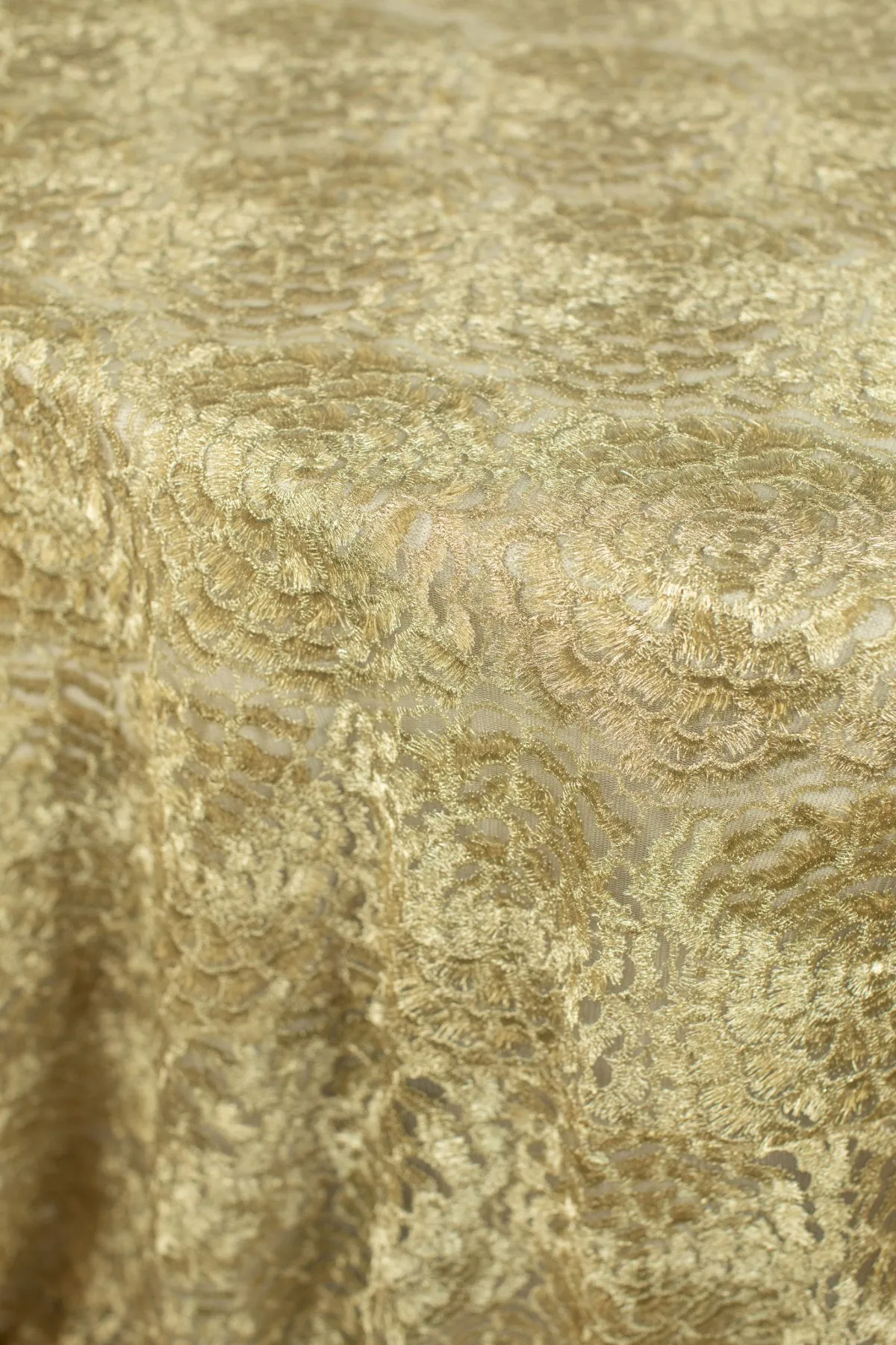 Gold floral brocade tablecloth with rich ornamental texture.