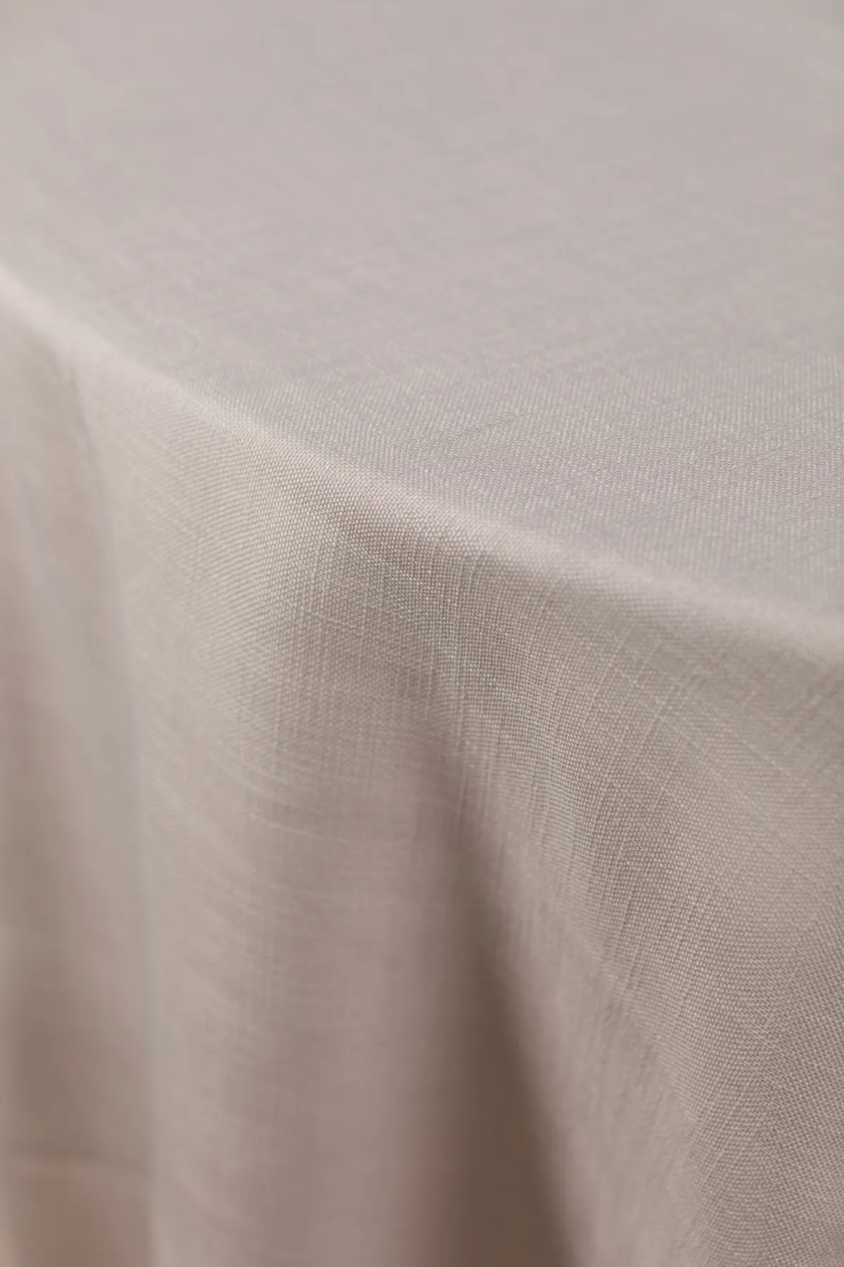 Neutral textured linen tablecloth with clean tailored drape.