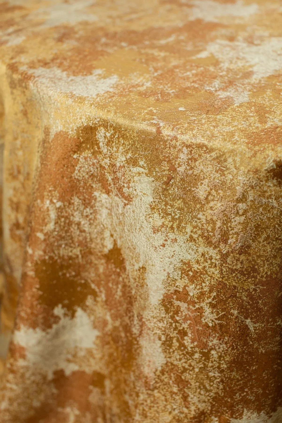 Gold textured tablecloth with distressed metallic pattern.