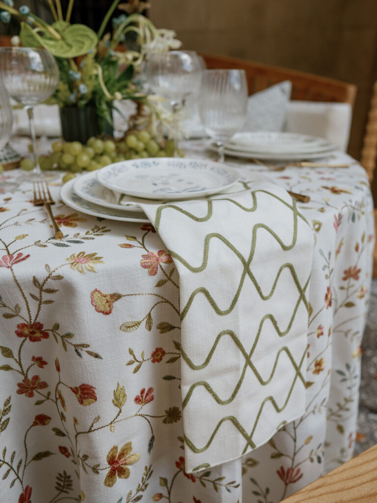 - Curated Linen Collection Round table covered with luxury linen fabric and floral centerpiece