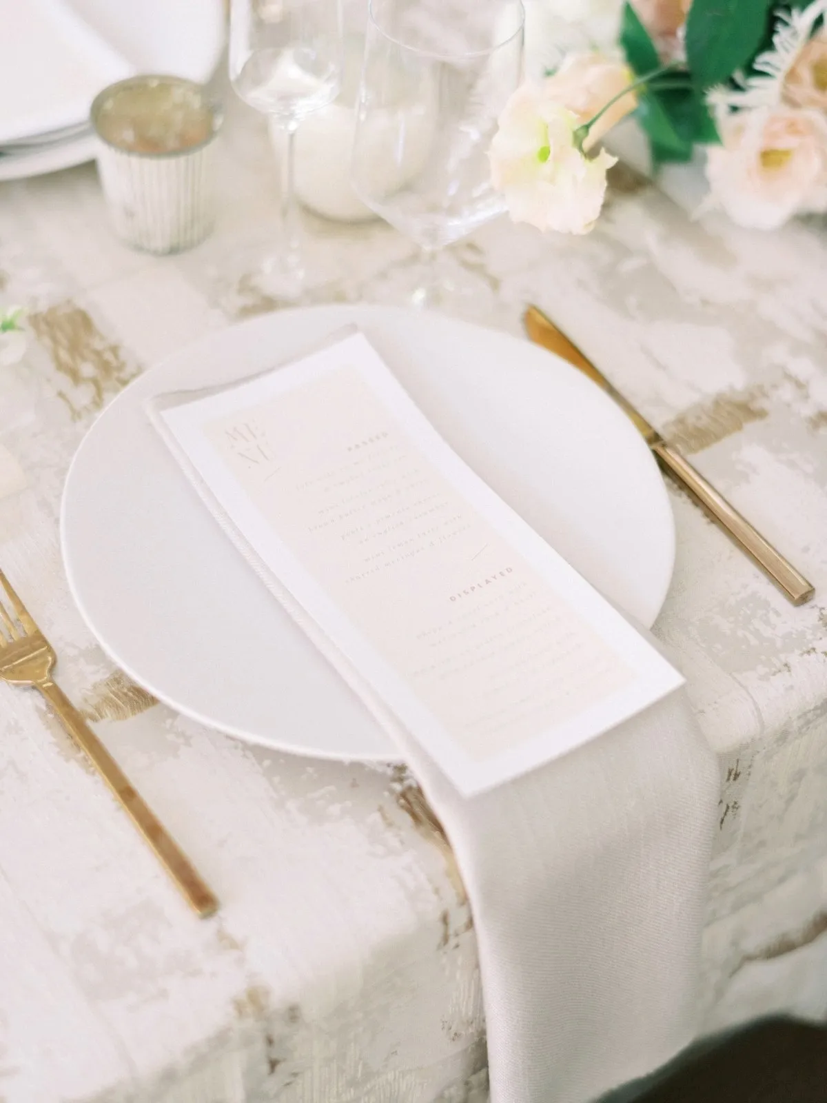 Neutral textured place setting with white china and gold flatware - Curated Linen Collection Neutral textured place setting with white china and gold flatware