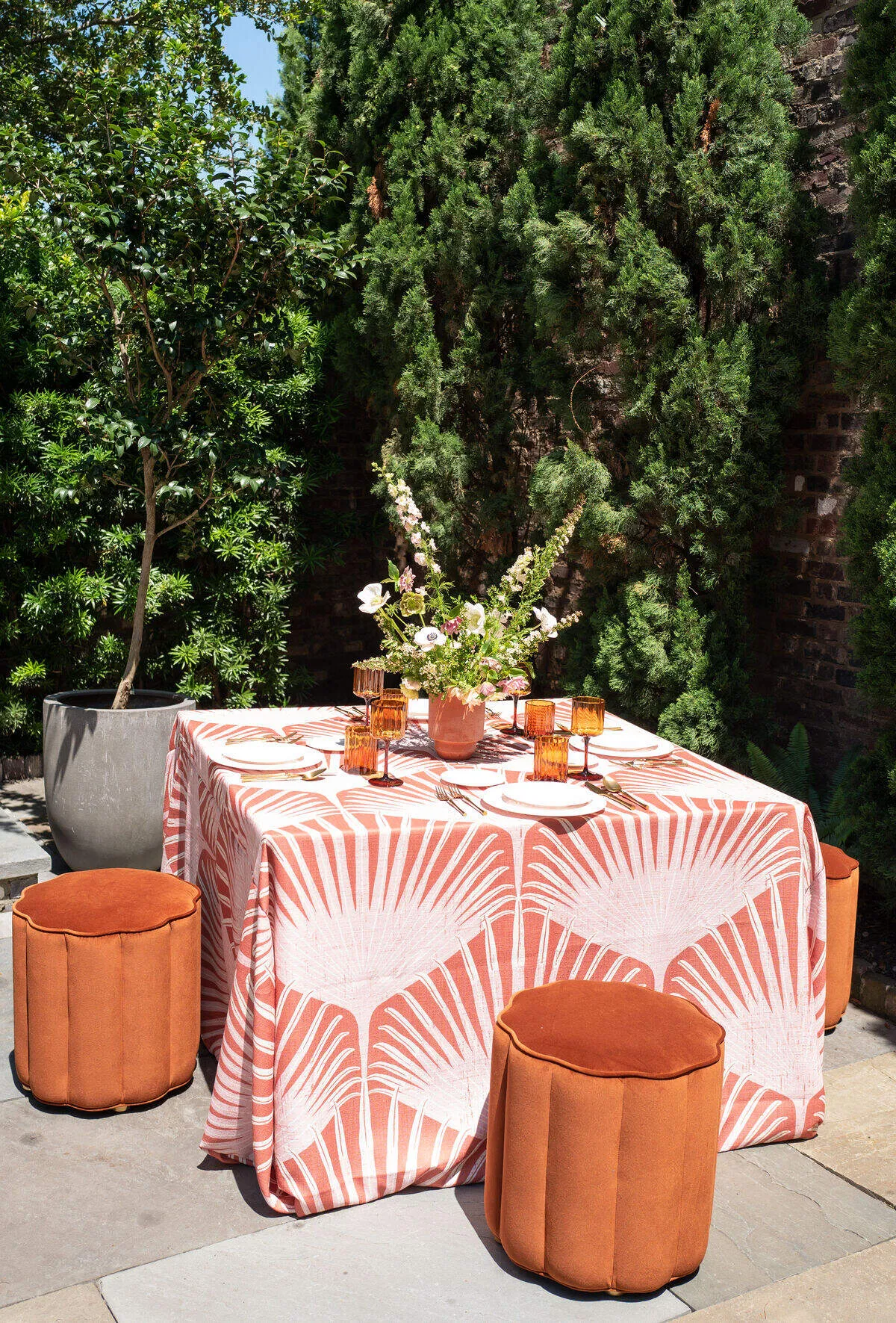 - Curated Linen Collection Custom-printed linen tablecloth with a geometric pattern and coordinating orange accents, setting a distinctive tablescape.
