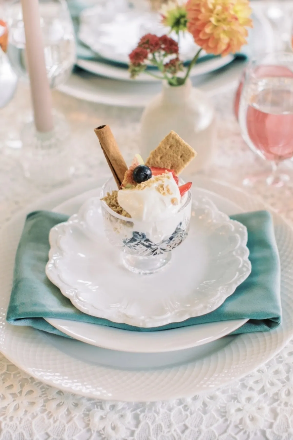 Teal napkin layered beneath white dinnerware on a textured foundation table linen - Curated Linen Collection Teal napkin layered beneath white dinnerware on a textured foundation table linen